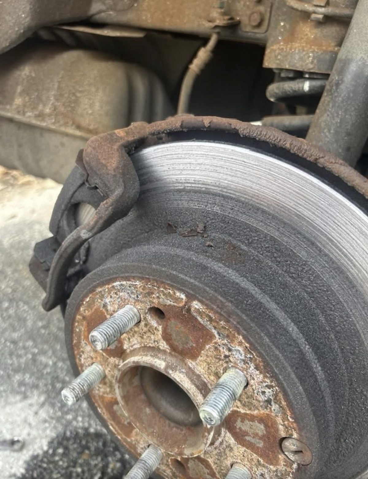 Rusted and grooved brake rotor before replacement at a customer's home